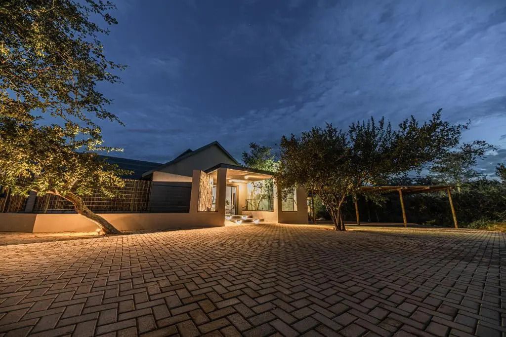 Eingangsbereich eines luxuriösen Hotels bei Nacht mit gepflastertem Vorplatz