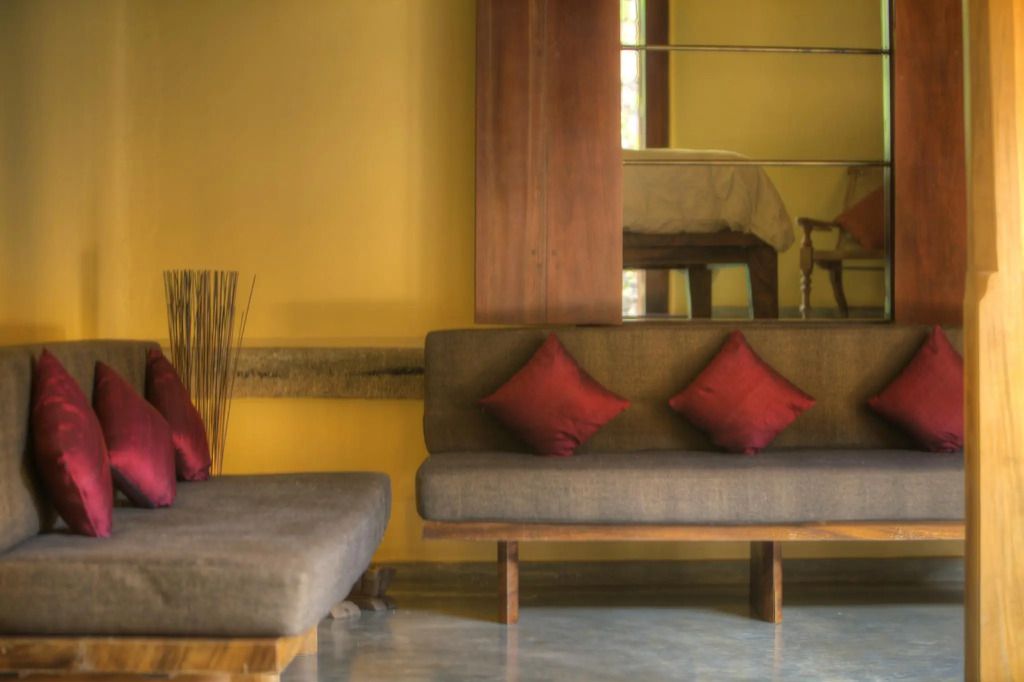 Elegante Lounge mit roten Kissen auf einem Sofa in einem warm beleuchteten Raum