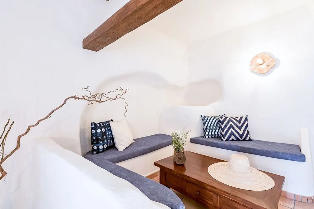 Gemütliche Sitzecke mit Holzmöbeln und dekorativen Kissen im Zimmer