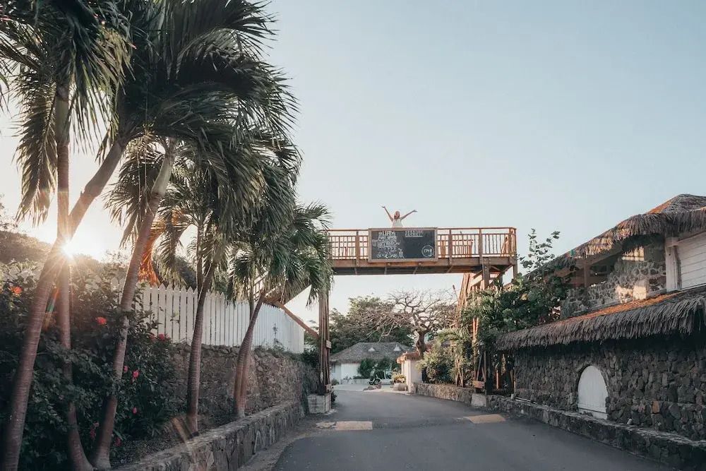Erhöhte Plattform mit Blick auf eine palmengesäumte Straße bei Sonnenuntergang