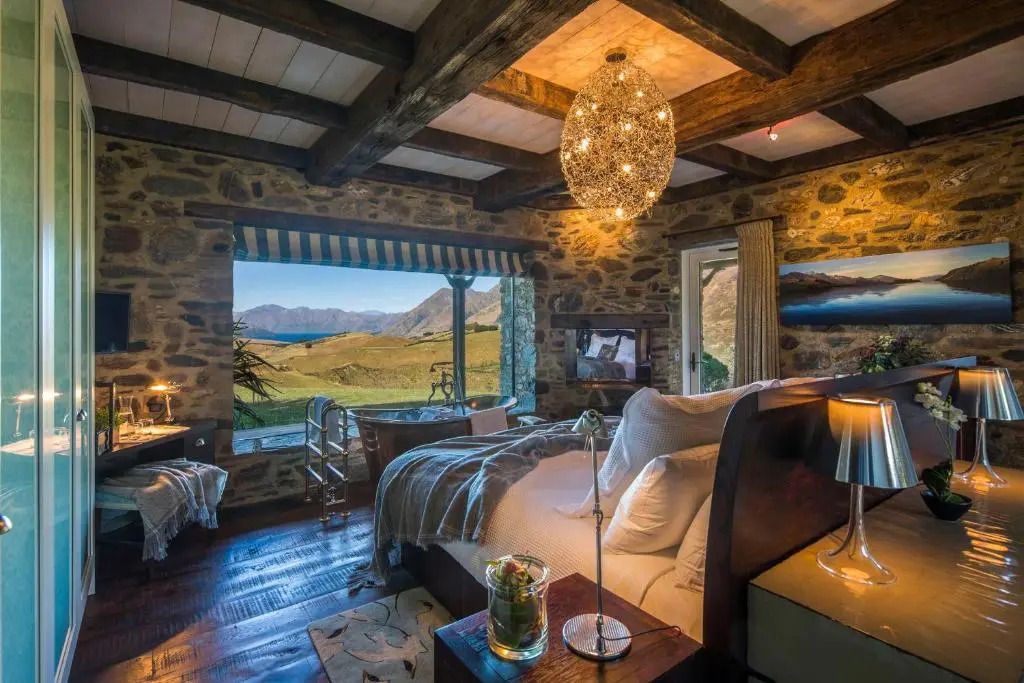 Rustikales Schlafzimmer mit Holzbalkendecke und Panoramablick auf die Landschaft