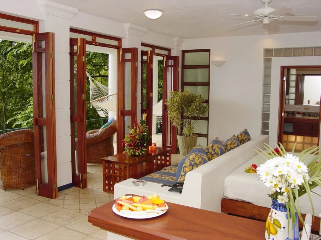 Helles Wohnbereich mit offener Terrasse und Blick auf den tropischen Garten