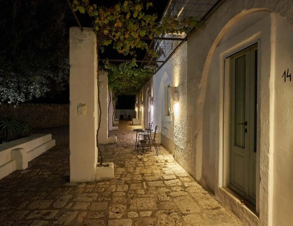 Stimmungsvolle Terrasse bei Nacht mit Steinboden und beleuchteter Fassade