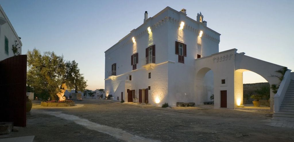 Traditionelles weißes Gebäude von Masseria Torre Coccaro bei Abenddämmerung