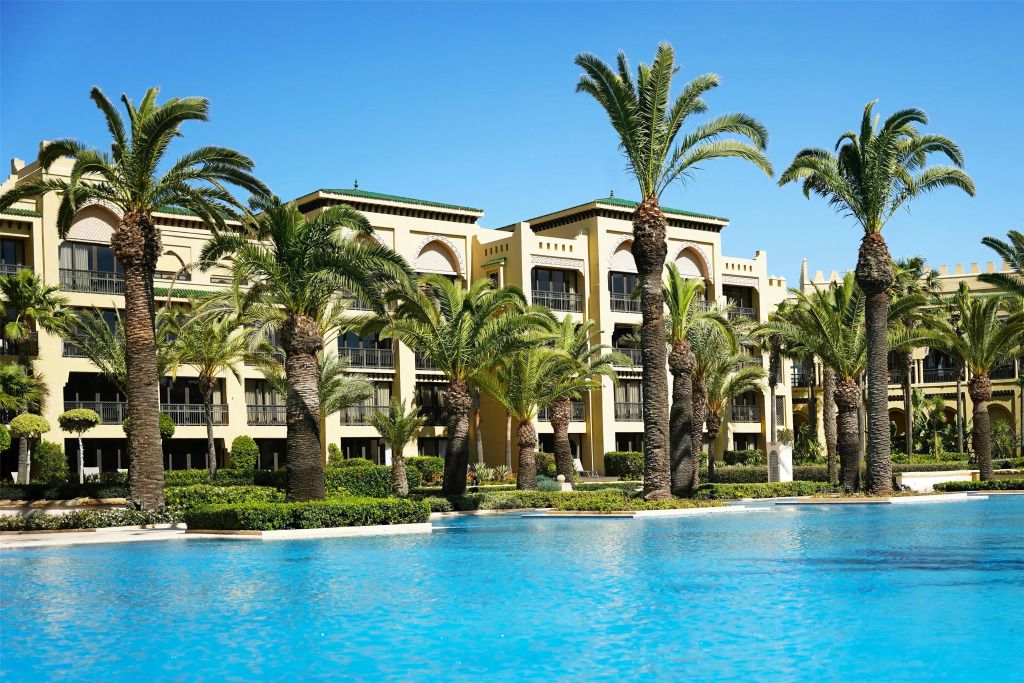 Außenansicht des Mazagan Beach & Golf Resort mit Palmen und großem Pool