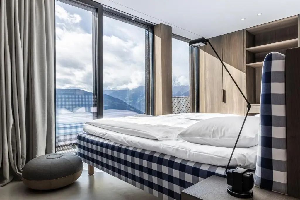 Modernes Hotelzimmer mit großem Fenster und Alpenblick