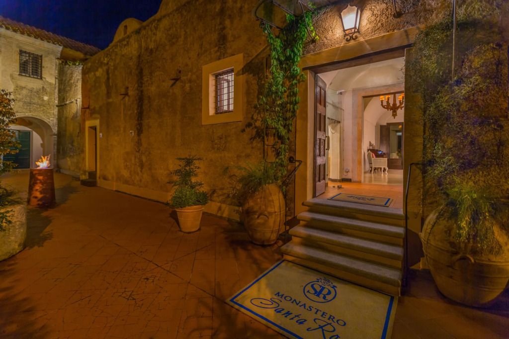 Historische Hotelfassade bei Nacht mit offenem Eingang und rustikalem Charme