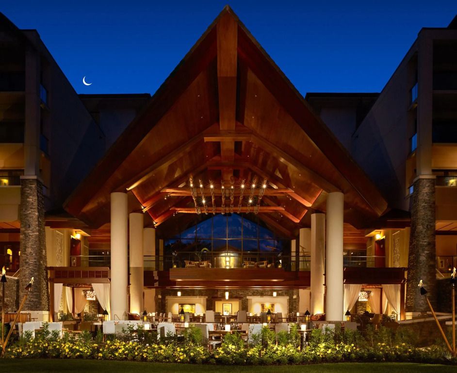 Stylische und beeindruckende Hotelarchitektur bei Nacht mit Gartenbeleuchtung.