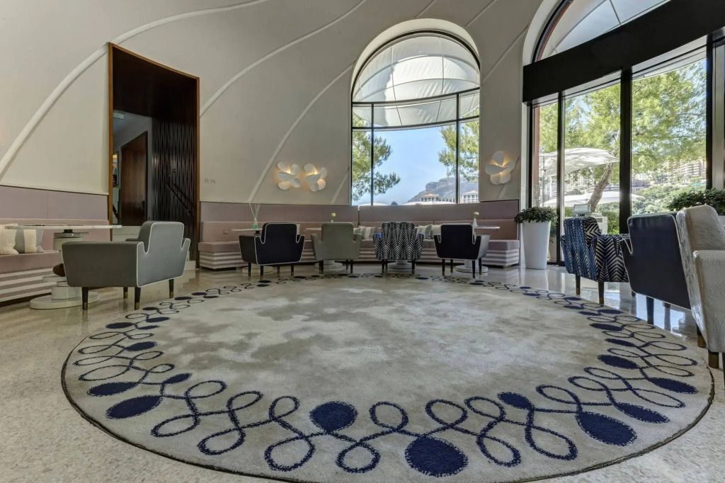 Eleganter Loungebereich mit moderner Inneneinrichtung und großen Fenstern.