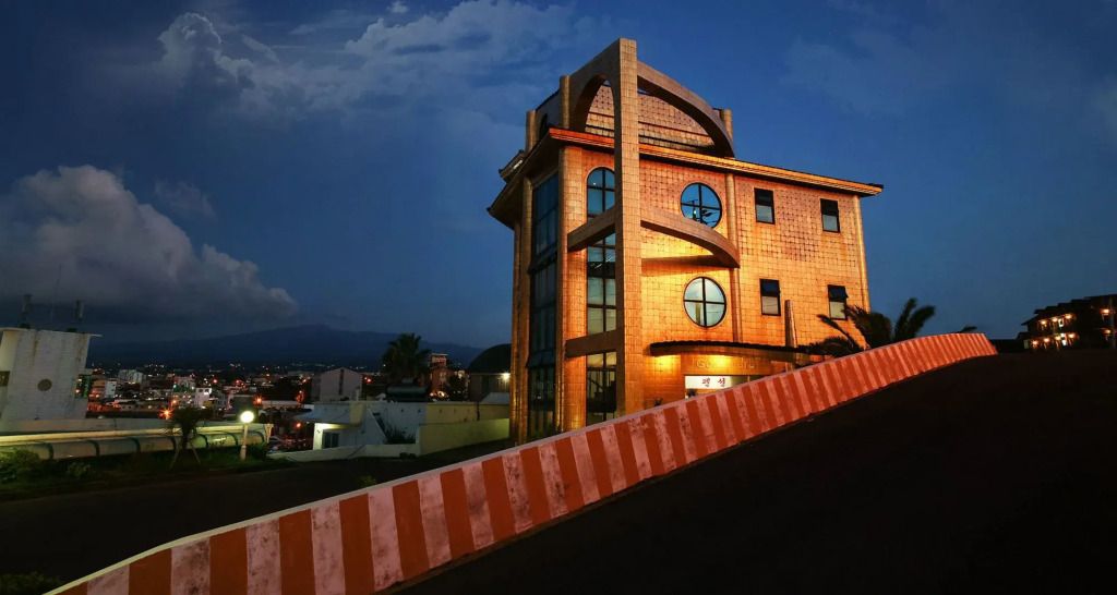 Hotelgebäude bei Nacht mit markanter Architektur und beleuchtetem Eingang