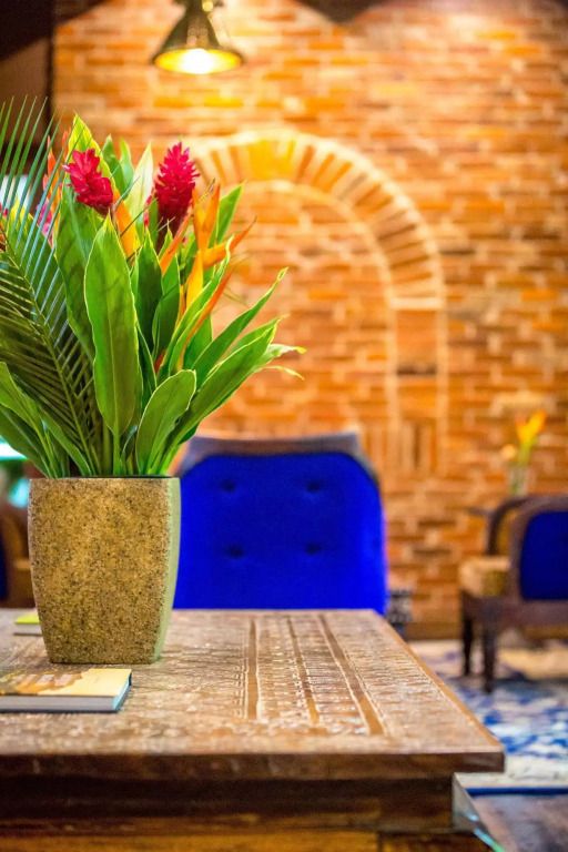 Elegante Lounge mit roten Blumen und Backsteinwand