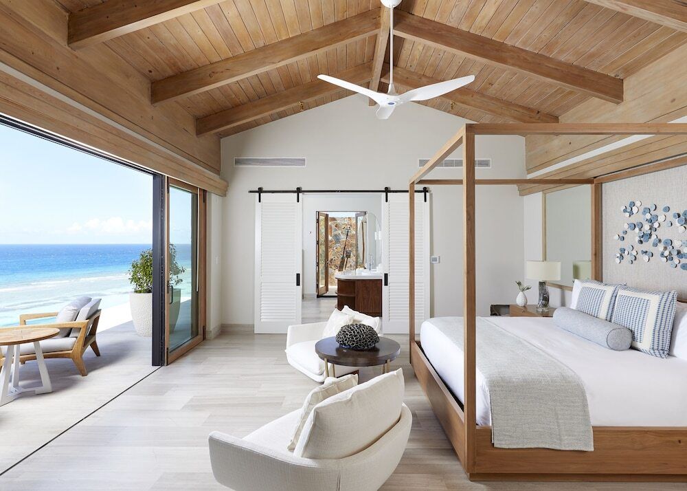 Helles Schlafzimmer mit Blick auf das Meer und modernen Holzakzenten