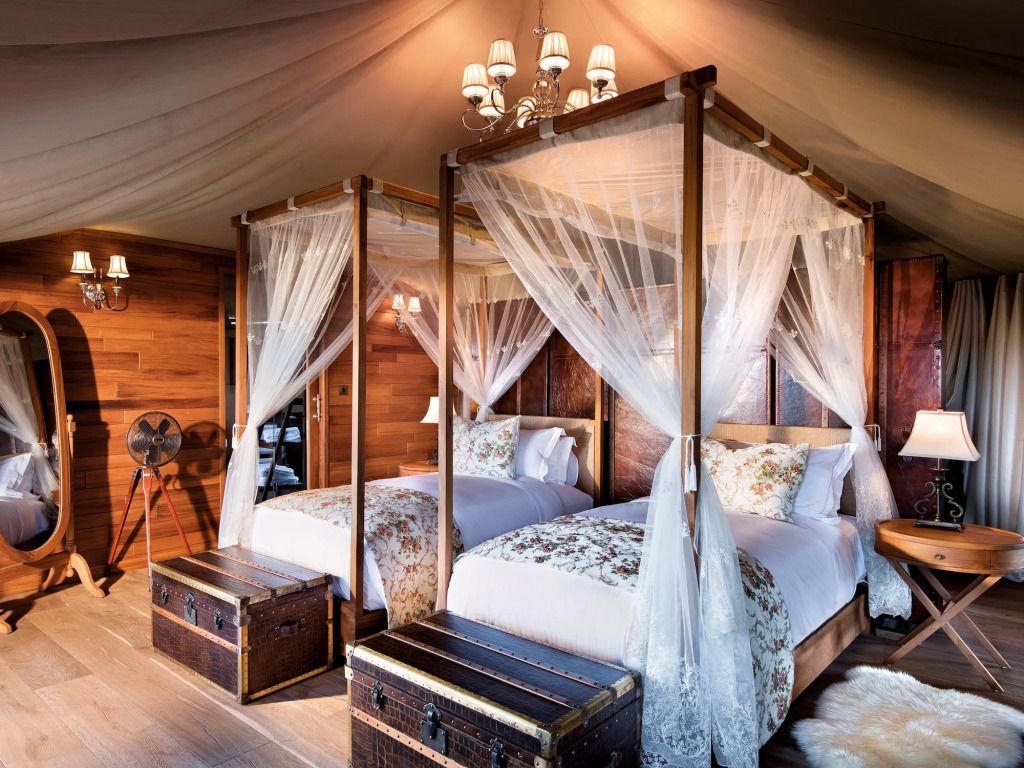 Zwei luxuriöse Einzelbetten mit Baldachin in einem elegant eingerichteten Zeltzimmer