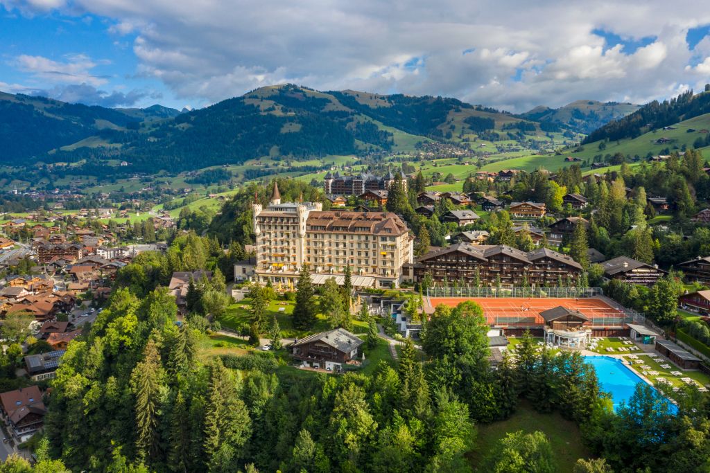 Panoramablick auf das Gstaad Palace umgeben von Alpenlandschaft