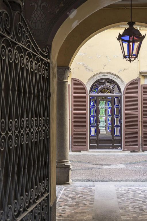 Historischer Innenhof mit verzierten Toren und hölzernen Fensterläden