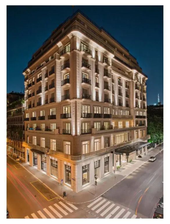 Beleuchtete Fassade des Palazzo Parigi Hotels bei Nacht