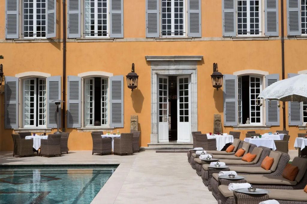 Elegante Fassade des Hotels mit Pool und Sonnenliegen