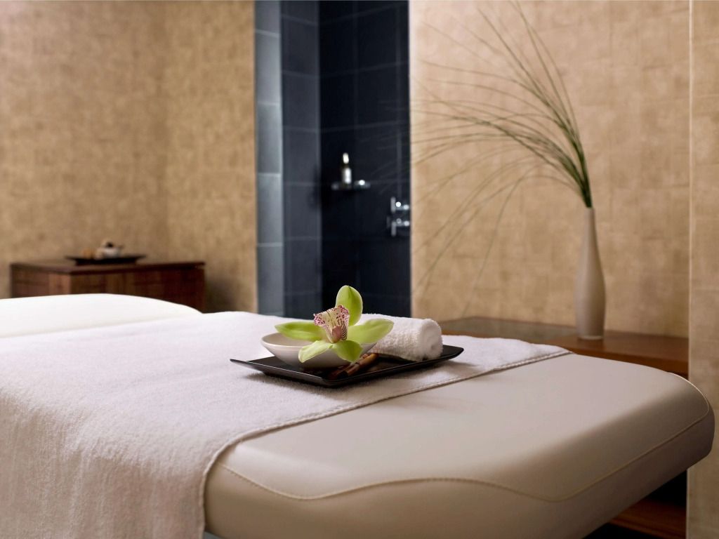 Massagebett im Spa mit Handtuch und Blume, entspannende Atmosphäre.