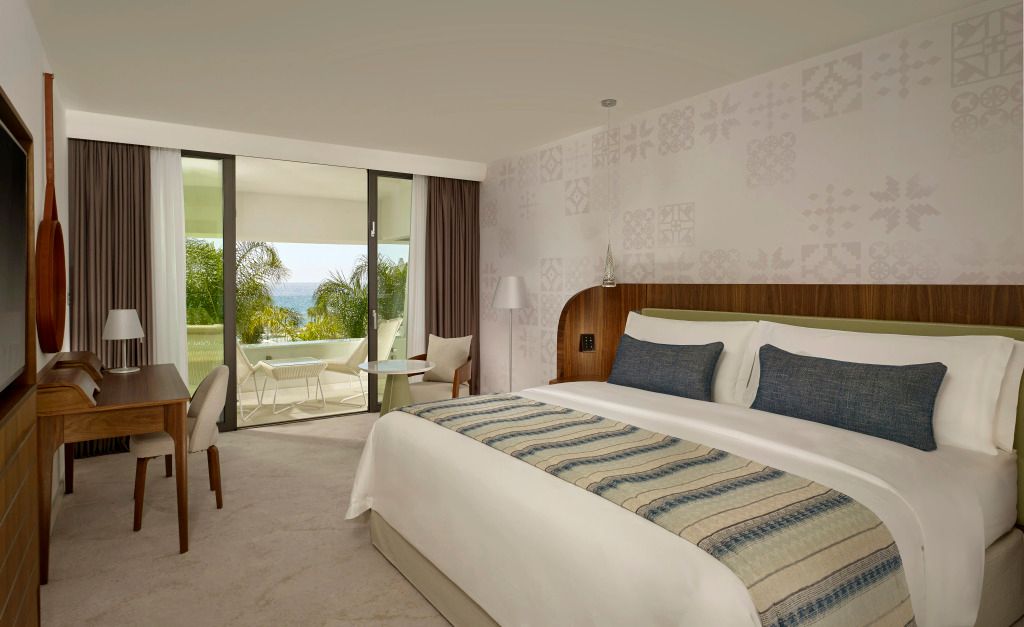 Luxuriöses Hotelzimmer mit Doppelbett und Balkon mit Meerblick