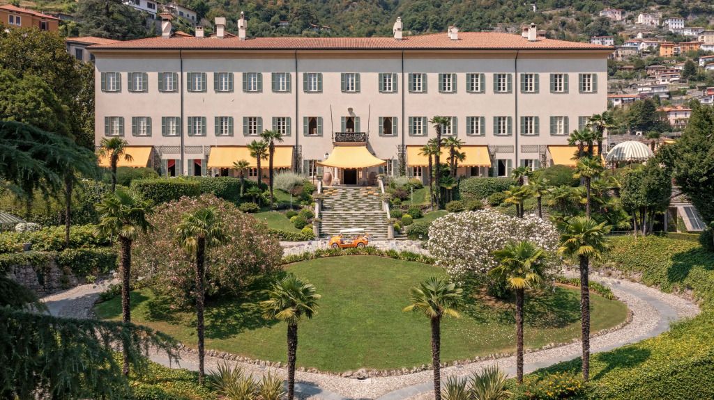 Elegante Fassade des Hotels Passalacqua mit gepflegtem Garten und Palmen