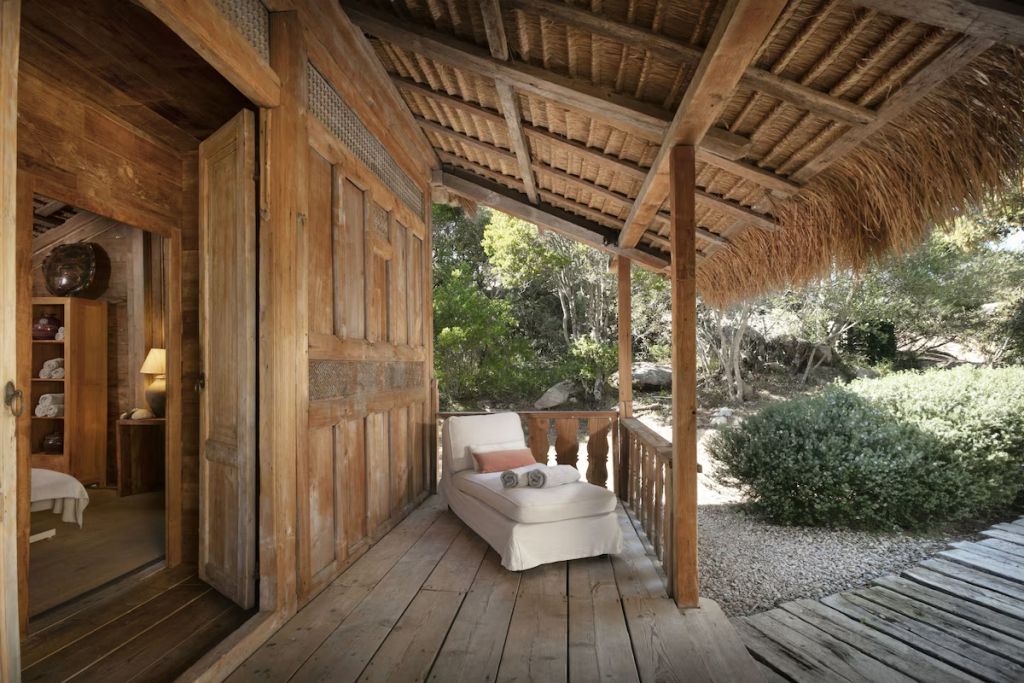 Holzveranda mit Liegestuhl und Blick auf den Garten im Petra Segreta Resort