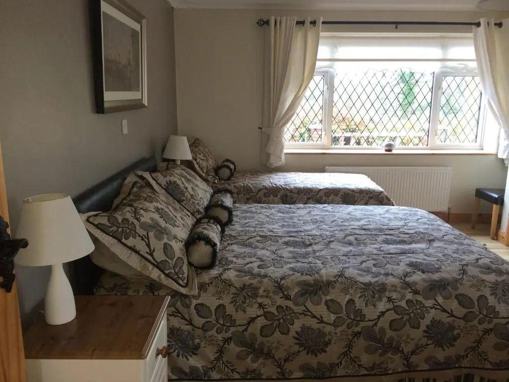 Gemütliches Doppelzimmer mit großen Fenstern und Blumendekor