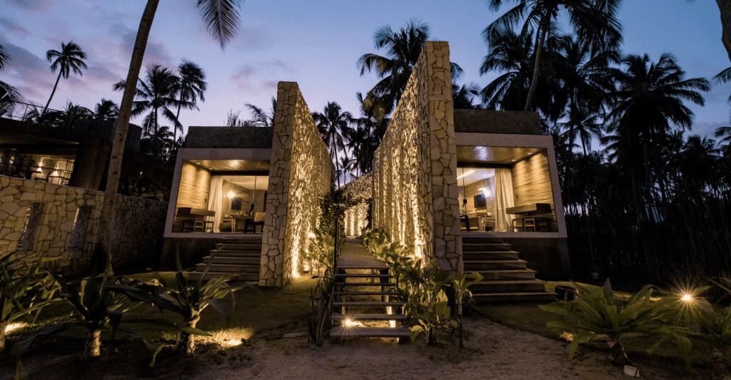 Außenansicht eines stilvollen Steingebäudes bei Dämmerung mit Beleuchtung.