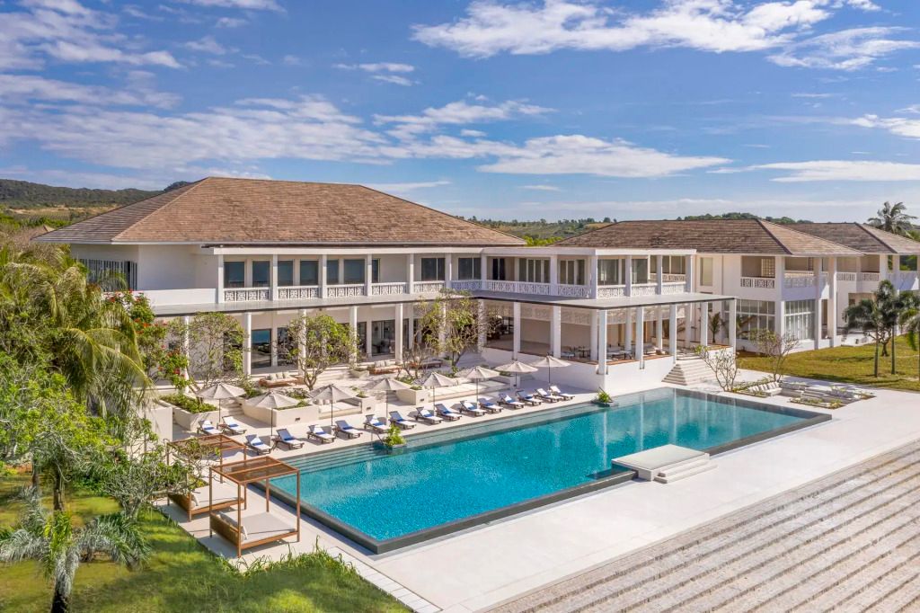 Luxuriöser Hotelpool mit Sonnenschirmen und moderner Architektur unter blauem Himmel