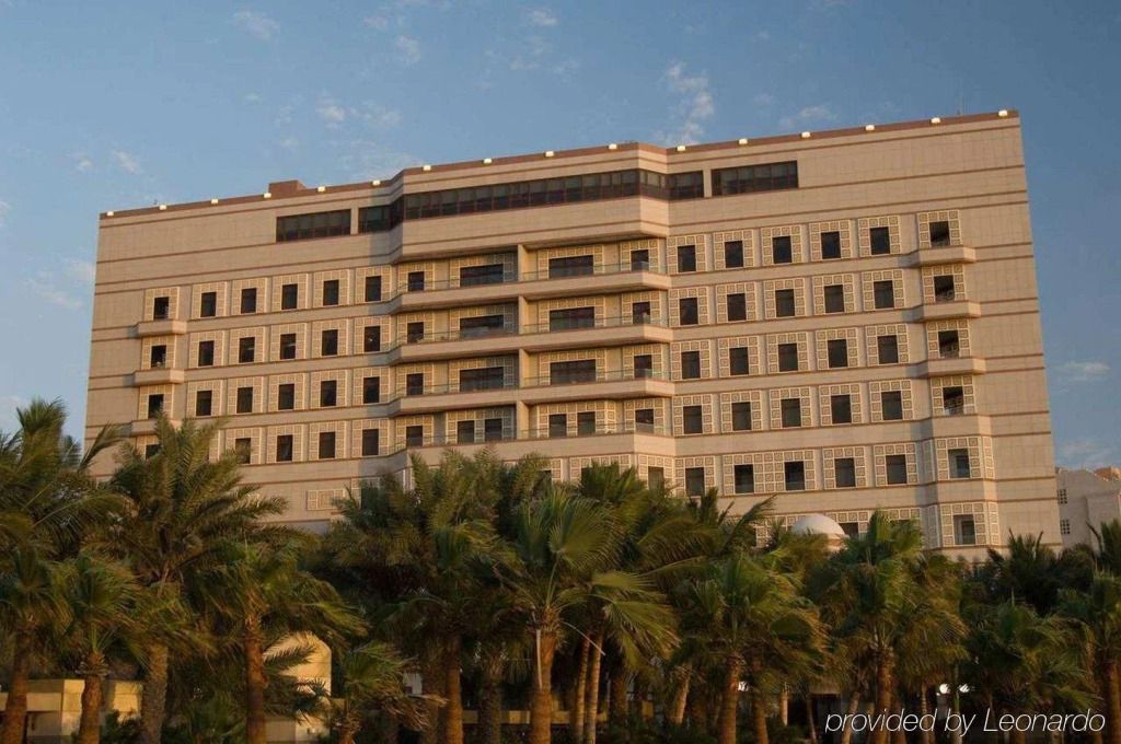 Fassade des Waldorf Astoria Jeddah mit Palmen im Vordergrund
