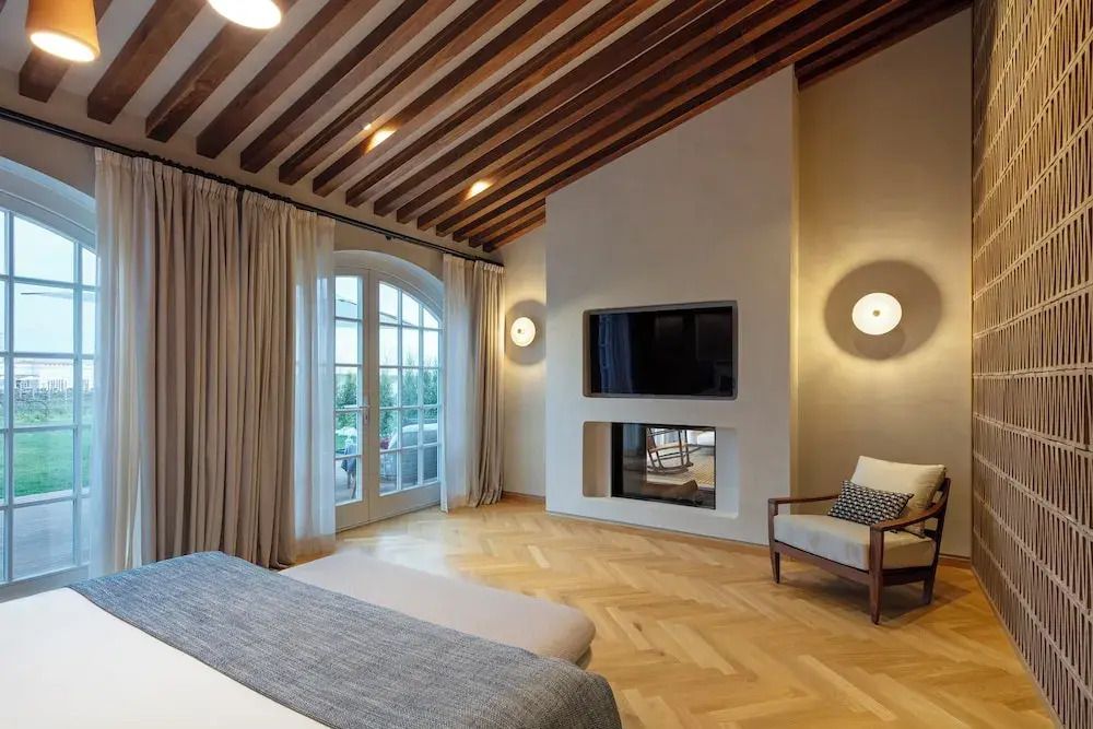 Elegantes Hotelzimmer mit Holzbalkendecke und großem Fenster