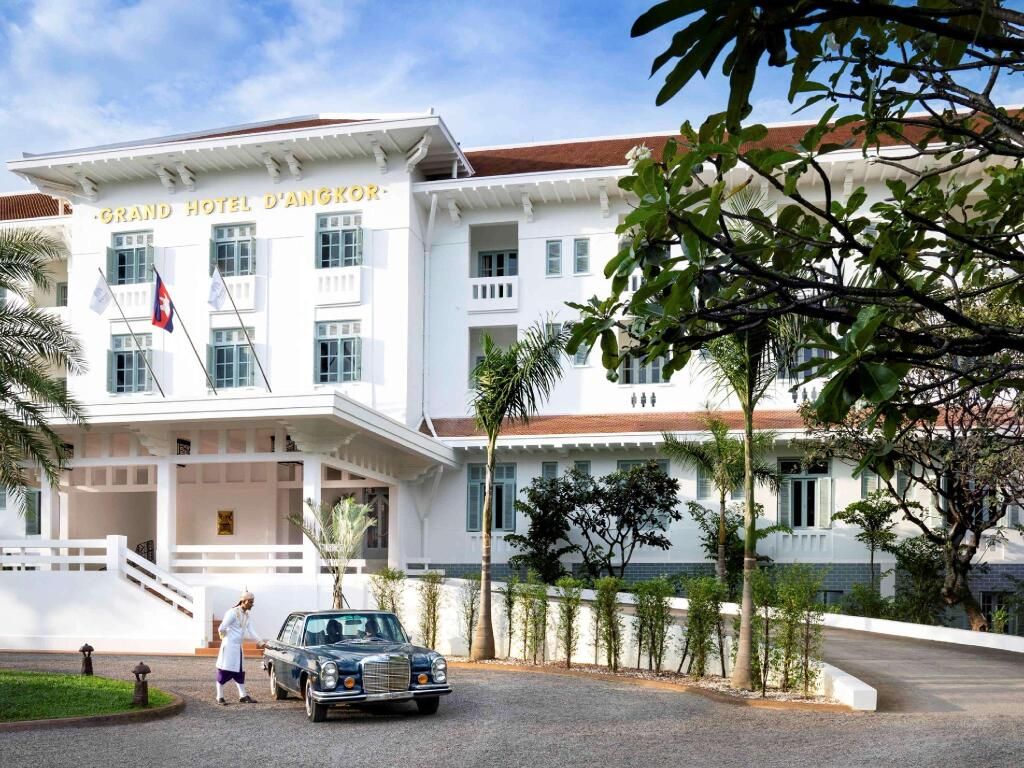 Klassische Fassade des Raffles Grand Hotel d'Angkor mit Oldtimer im Vordergrund
