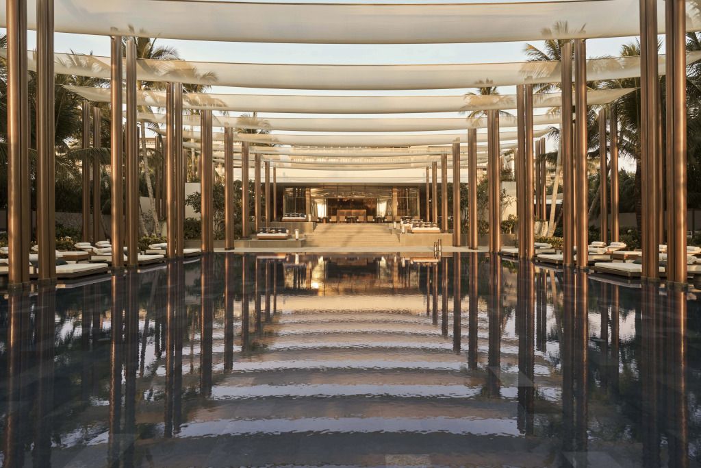 Schöner überdachter Poolbereich mit eleganter Architektur und Palmen.