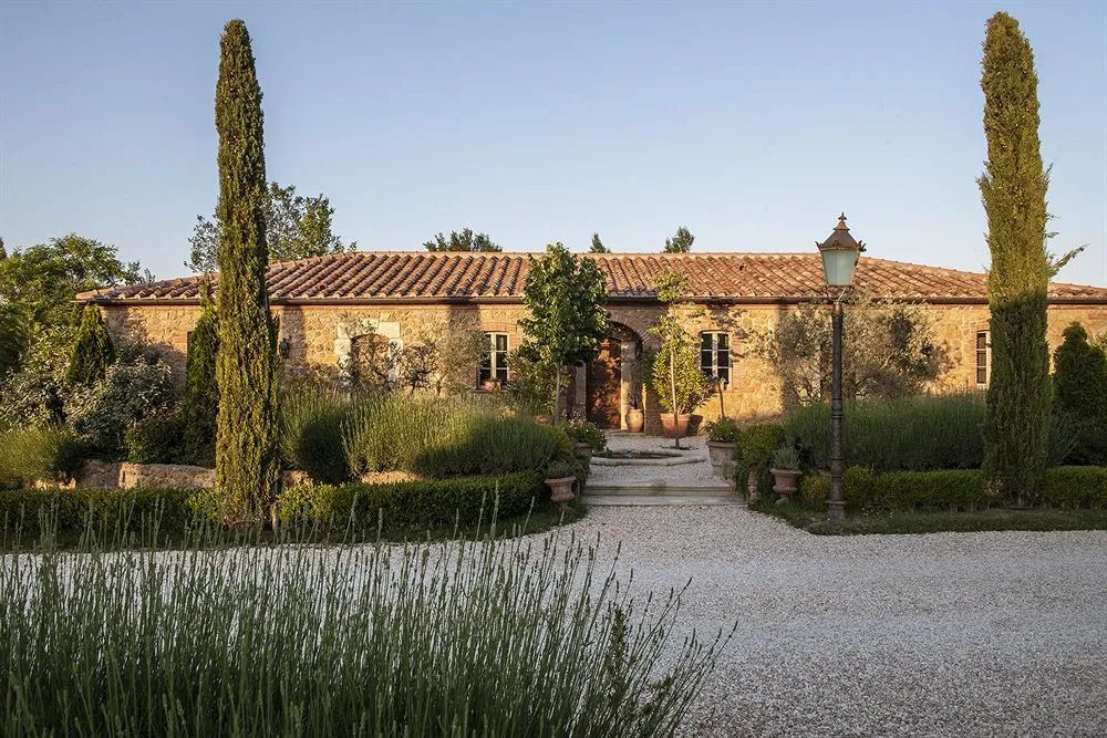 Rustikale Steinfassade mit gepflegtem Garten im Borgo Santo Pietro