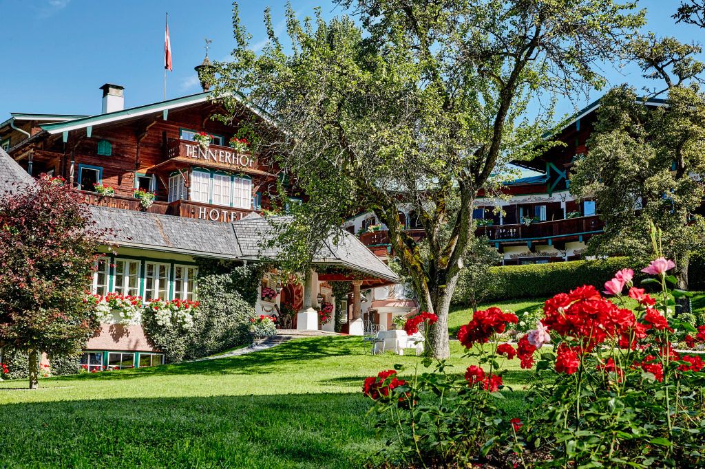 Idyllischer Garten des Relais & Châteaux Hotel Tennerhof mit Fachwerkhaus und Blumen.