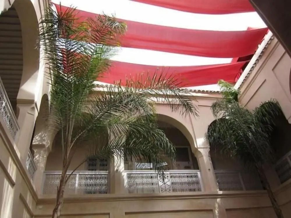 Innenhof mit Palmen und rot-weißem Sonnensegel im Hotel AnaYela