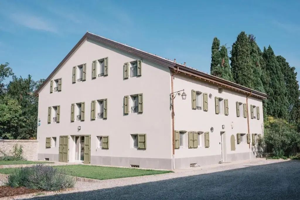 Historisches Gebäude mit weißer Fassade und grünen Fensterläden