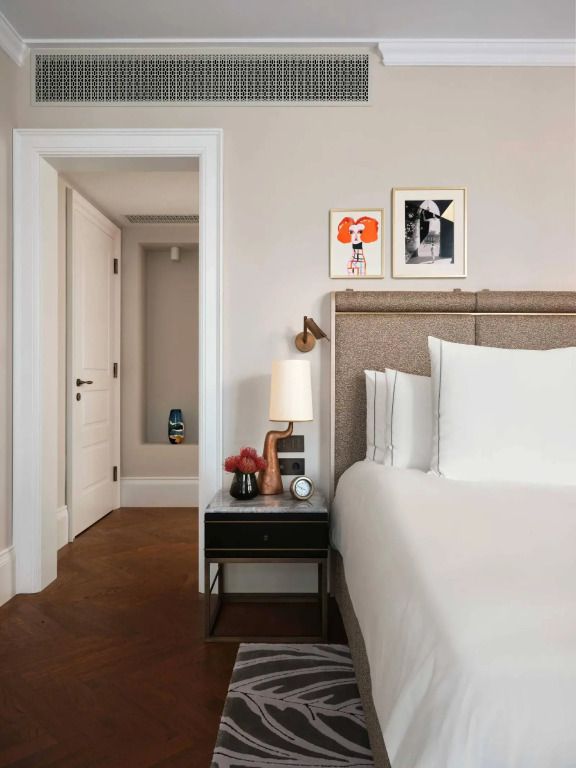 Elegantes Hotelzimmer mit minimalistischem Dekor und modernem Kunstwerk an der Wand