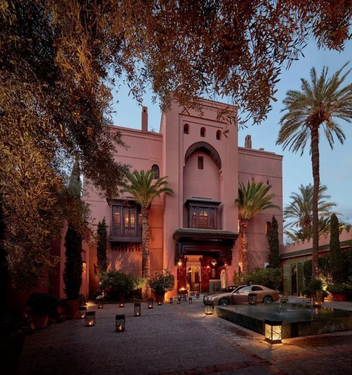 Eindrucksvolle Fassade des Royal Mansour Marrakech mit Palmen und leisem Abendlicht