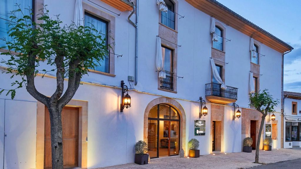 Hoteleingang des Sa Creu Nova mit moderner Beleuchtung und traditioneller Architektur.