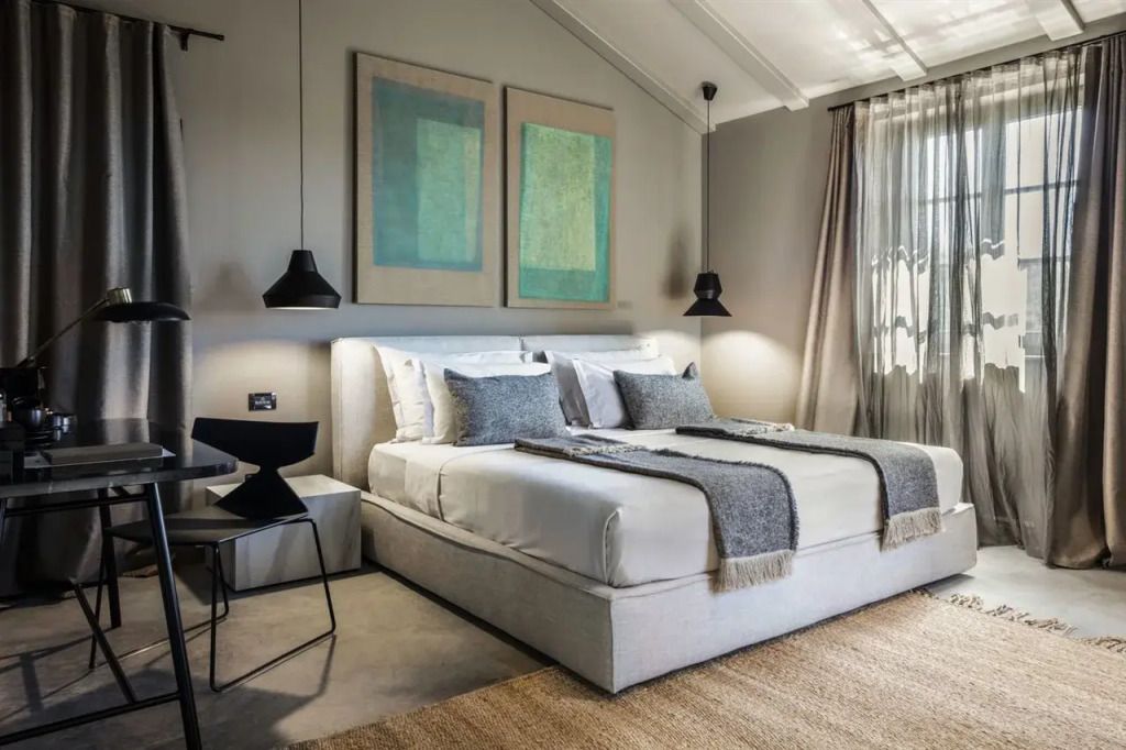 Luxuriöses Schlafzimmer mit stilvollem Doppelbett und eleganter Kunst im San Canzian Hotel