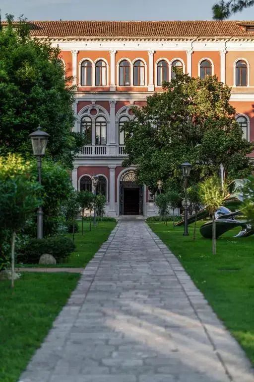 Historische Fassade mit gepflegtem Garten und einladendem Eingang.
