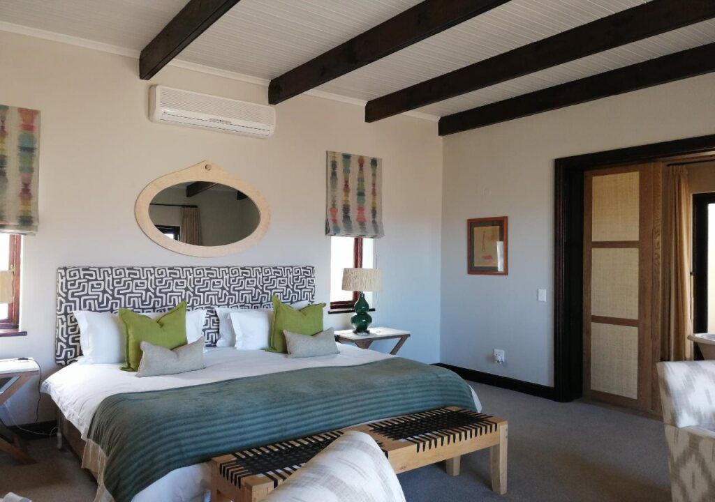 Elegantes Schlafzimmer mit Holzbalken und grünem Dekor