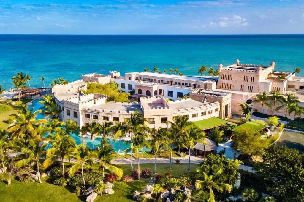 Luxuriöses Hotelresort am türkisblauen Meer umgeben von Palmen in Cap Cana.