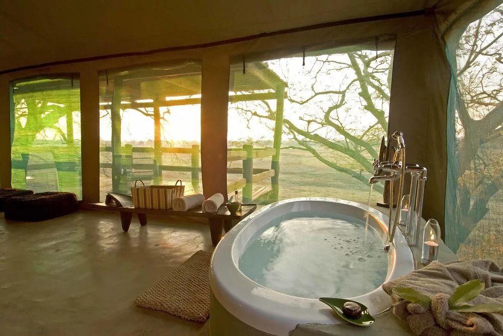 Luxuriöse Badewanne mit Blick auf die afrikanische Savanne bei Sonnenuntergang