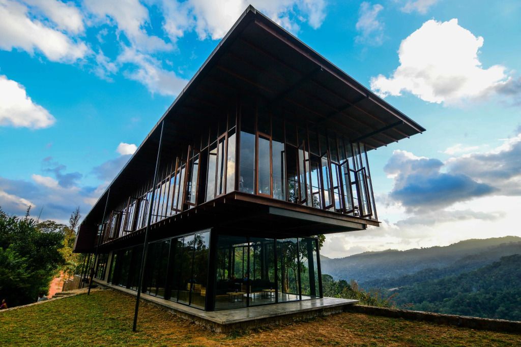 Modernes Gebäude mit großen Fenstern und Blick auf die Hügel