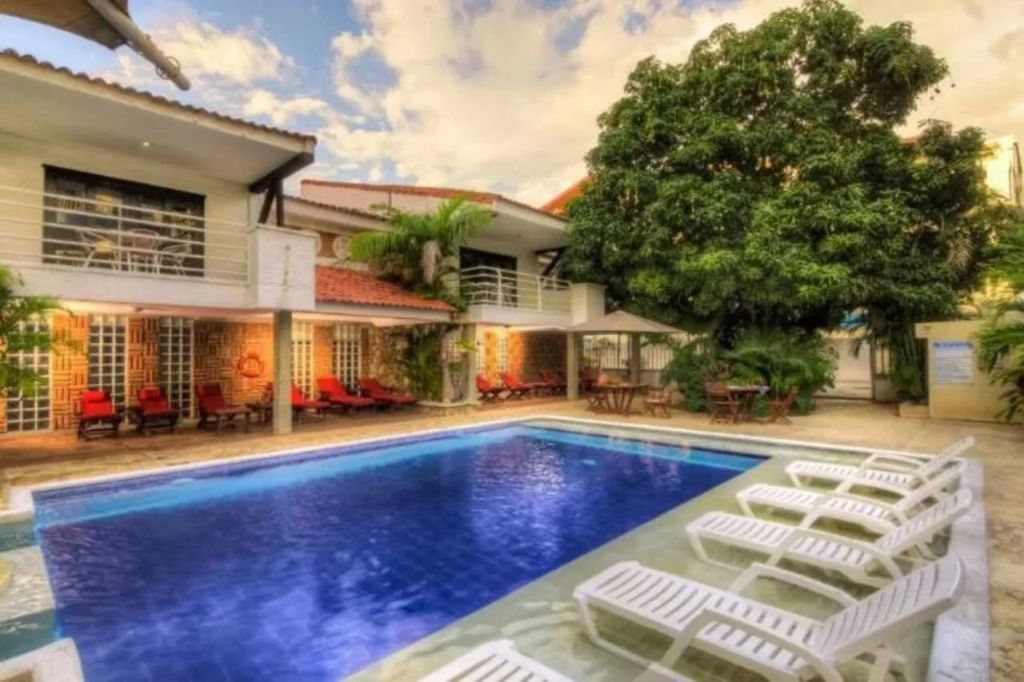 Außenpool mit Liegestühlen und Bäumen im Hintergrund