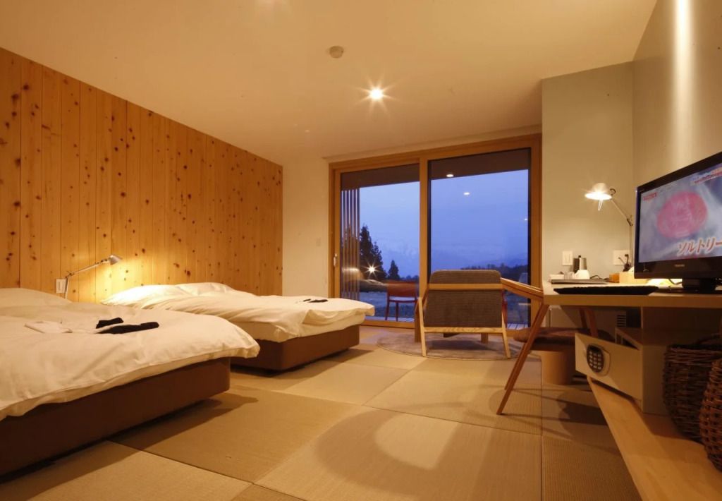 Modernes Hotelzimmer mit Tatamimatten und Blick auf die bewaldete Landschaft