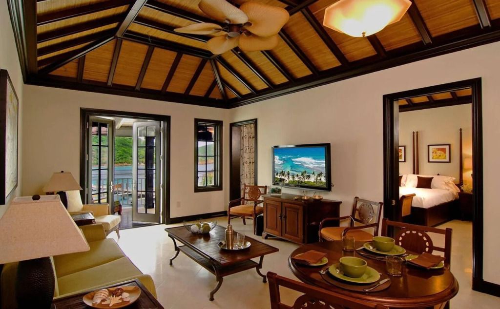 Luxuriöses Wohnzimmer mit Holzbalkendecke und großem Flachbildfernseher