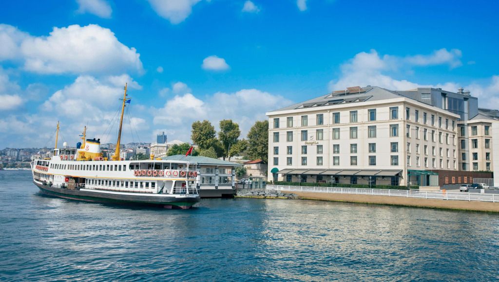 Außenansicht des Shangri-La Bosphorus am Wasser mit vorbeifahrendem Schiff