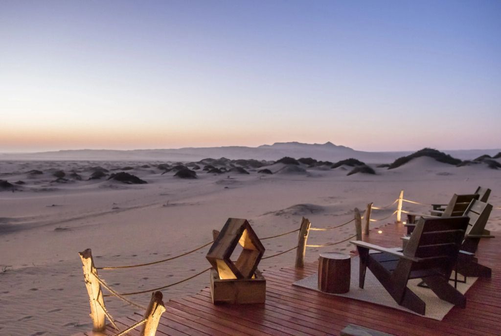 Terrasse der Shipwreck Lodge mit Blick auf die Dünen bei Sonnenuntergang